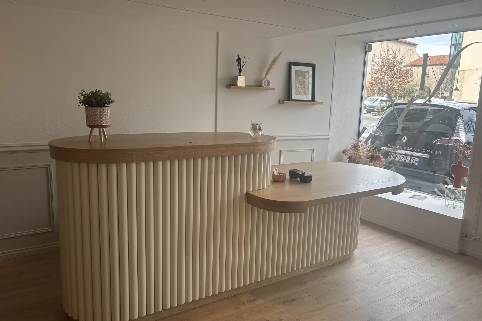 Le comptoir d’accueil cannelé, devant la vitrine ouverte sur le boulevard