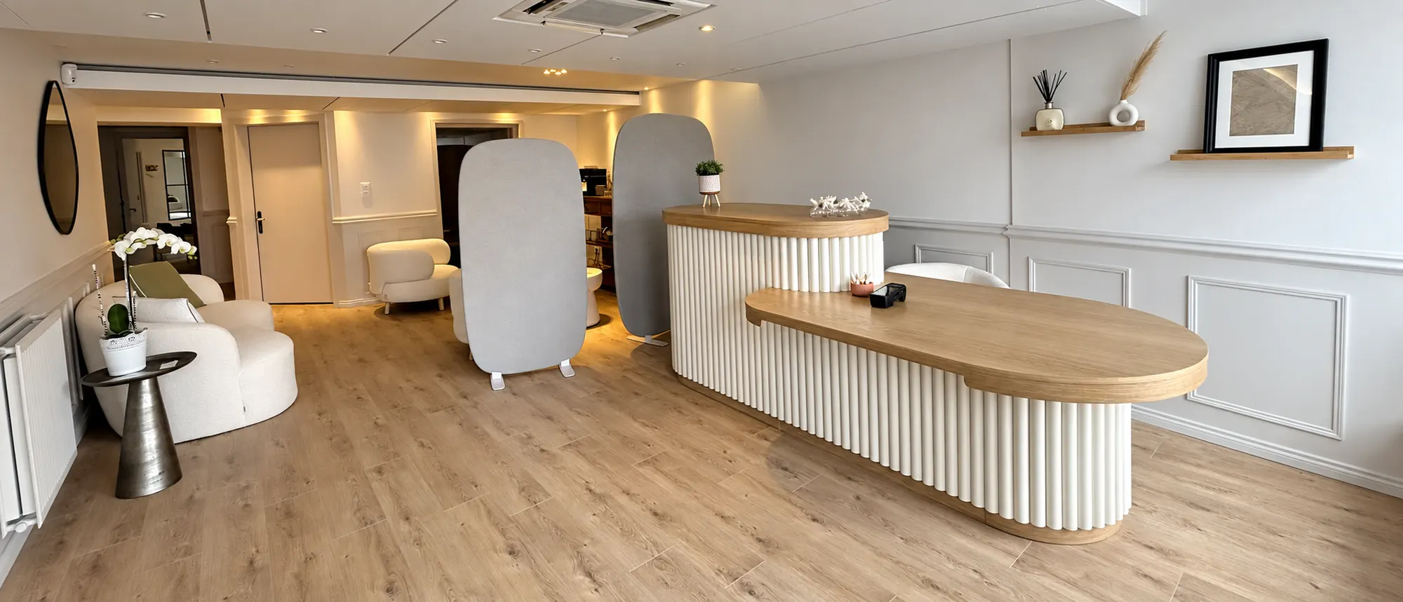 L’accueil vu depuis le couloir : comptoir cannelé, banquette, paravents